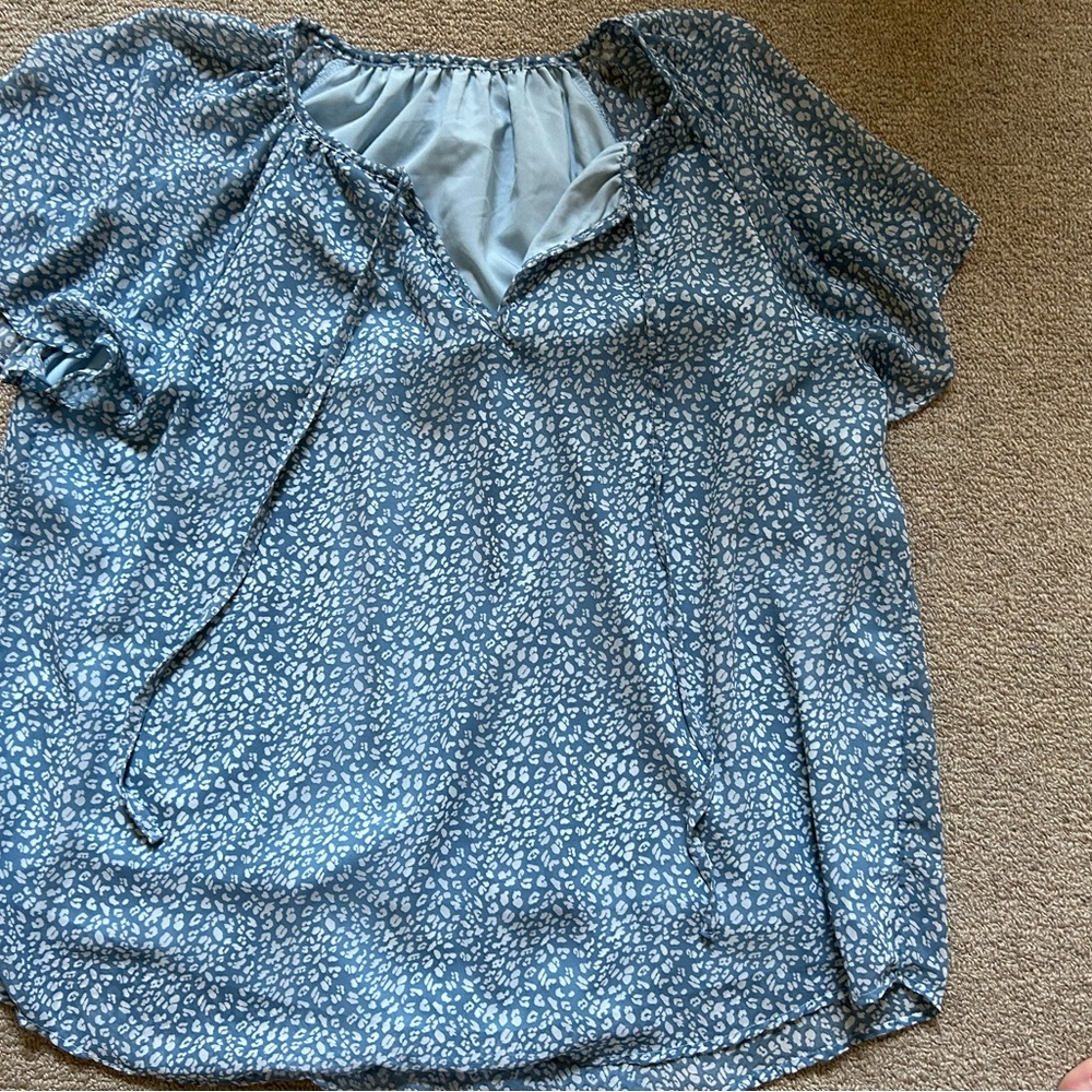 Polyester, blue & white blouse with two strings in the front. Flowy & runs big
